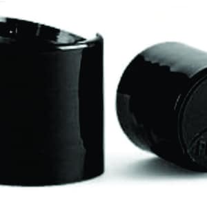 May include: Two black plastic pump bottle caps. The cap on the right has the word "PRESS" embossed on the top.