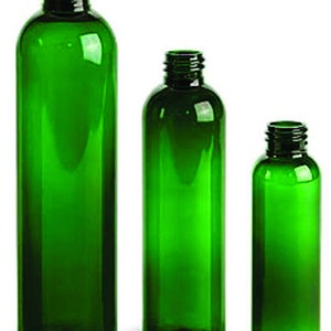 May include: Three green glass bottles of different sizes. The bottles are clear and have a smooth, rounded shape.