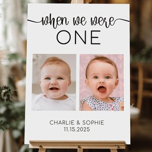 May include: White sign on an easel with the text "when we were ONE". Below the text are two photos of babies. The sign also includes the names "Charlie & Sophie" and the date "11.15.2025".