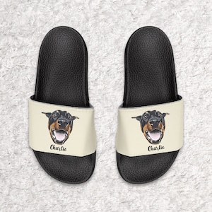 May include: A pair of black and white personalized slides with a dog's face and the name "Charlie" printed on the front.