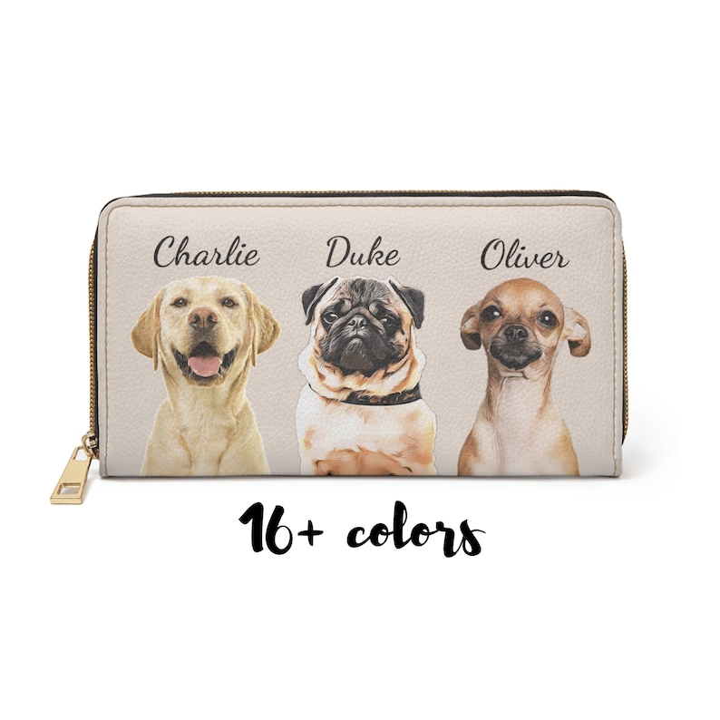 May include: A beige zippered wallet with three dogs on it. The dogs are a yellow lab, a pug, and a chihuahua. The dogs are labeled 'Charlie', 'Duke', and 'Oliver'. The text '16+ colors' is below the dogs.