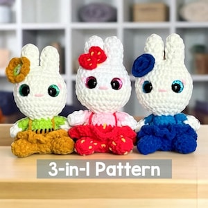 May include: Three handmade crochet bunny dolls with white bodies, each wearing a different outfit. One has a yellow and green outfit with a flower, another has a red strawberry dress and bow, and the third has a blue outfit and flower. The text "3-in-1 Pattern" is at the bottom.