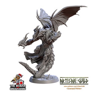 May include: A grey 3D printed miniature of a dragon-like creature with wings, claws, and a long tail. The creature is standing on a round base with a textured surface. The miniature is printed by Artisan:Guild.