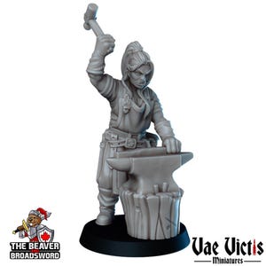May include: A gray miniature of a blacksmith, holding a hammer above an anvil. The figure is wearing a leather apron and has a ponytail. The base of the miniature is black. The Beaver Broadsword and Vae Victis logos are visible.