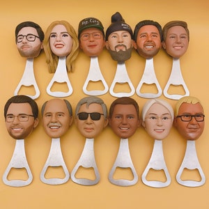 May include: A collection of personalized bottle openers featuring sculpted faces. Each opener has a unique face with varying hairstyles, glasses, and expressions. The openers are made of silver metal and are arranged on a yellow background.