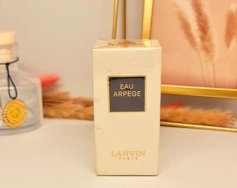 May include: A white box with gold lettering that reads "Eau de Arpege" and "Lanvin Paris".