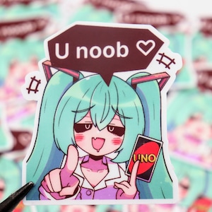 May include: A sticker featuring an anime-style character with teal hair, holding an "UNO" card. The character has a speech bubble that says "U noob" with a heart symbol. The sticker has a white border.