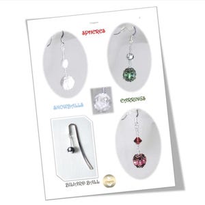 May include: A product display sheet featuring various spherical jewelry items. The text reads SPHERES, SNOWBALLS, EARRINGS, and BILLIARD BALLS. The image displays dangling earrings with clear, green, and red beads, plus a single billiard ball charm.