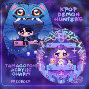 May include: Two acrylic Tamagotchi charms with a KPop Demon Hunters theme. One charm is a blue cat with a character, the other is an oval with a character and two smaller figures. The charms have the text "Tamagotchi Acrylic Charm Preorder".