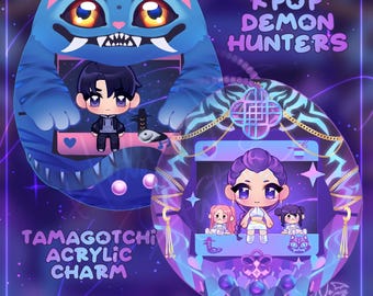 May include: Two acrylic Tamagotchi charms with a KPop Demon Hunters theme. One charm is a blue cat with a character, the other is an oval with a character and two smaller figures. The charms have the text "Tamagotchi Acrylic Charm Preorder".