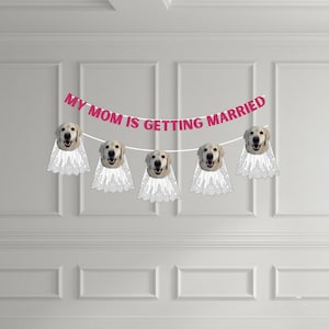 May include: A decorative banner featuring the text MY MOM IS GETTING MARRIED in pink letters. The banner includes five cutouts of golden retriever dog faces, each wearing a white lace veil, strung together on a white cord for display.