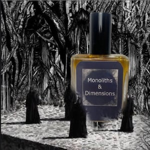 May include: A glass bottle of perfume with a black cap and a label that reads "Monoliths & Dimensions". The bottle is sitting on a black and white background with a dark forest scene.