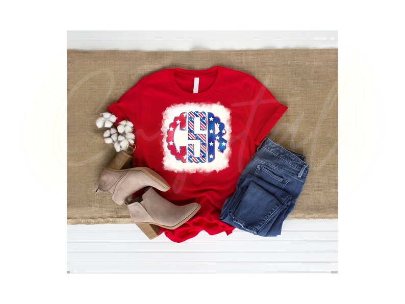 K&ouml;nnte beinhalten: Rotes T-Shirt mit einem wei&szlig;en, blauen und roten Monogramm-Design mit Sternen und Streifen. Das Monogramm ist der Buchstabe "C".