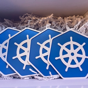 Peut inclure: Quatre sous-verres hexagonaux bleus et blancs avec un motif de volant blanc. Les sous-verres sont dans une boîte blanche avec du papier blanc déchiqueté.