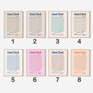 May include: Eight framed "Guest Check" prints with various coloured backgrounds. Each print has the text "Guest Check" and the number "518327" at the top. The backgrounds are beige, pink, blue, green, and orange.