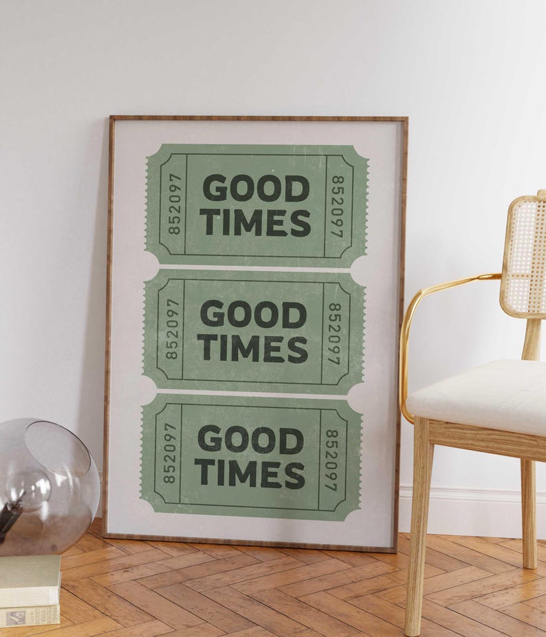 May include: A framed print featuring three green vintage-style tickets with the words "GOOD TIMES" in bold black letters. Each ticket has a unique serial number. The print is in a brown frame.