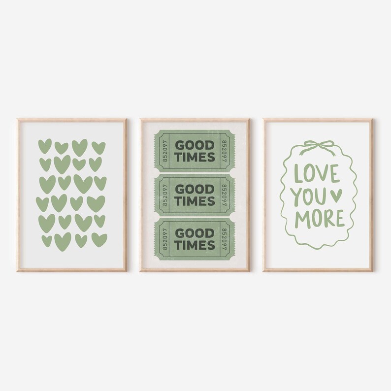 May include: Three framed art prints with a light wood finish. The prints feature a green heart pattern, three green "Good Times" tickets, and the phrase "Love You More" in green. The prints are on a white background.