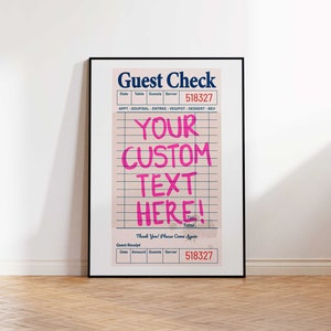 May include: Framed print of a guest check with the words "Guest Check" at the top. The check has a pink background with grid lines and the text "YOUR CUSTOM TEXT HERE!" in bright pink. The print is in a black frame.