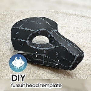 May include: Black DIY fursuit head template with white markings and the text "DIY fursuit head template". The template is made of a dark material and is cut into multiple pieces. The Manta Craft Studio logo is visible.