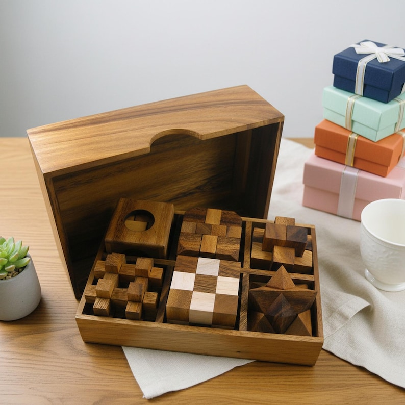 May include: A wooden puzzle set with various geometric shapes, including cubes, stars, and interlocking pieces, displayed in a wooden box. The set is accompanied by a stack of small gift boxes in blue, green, orange, and pink, tied with ribbons.
