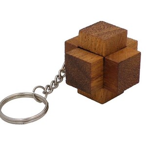 May include: A wooden puzzle keychain in the shape of a cube with a cross design. The keychain is made of light brown wood and has a silver metal ring.
