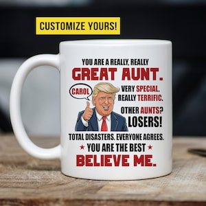May include: White ceramic coffee mug with a red and black design featuring a cartoon image of Donald Trump with the text "You are a really, really Great Aunt. Carol Very Special. Really Terrific. Other Aunts? Losers! Total Disasters. Everyone agrees. You are the best. Believe me."