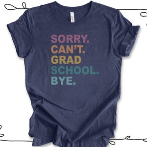 Może przedstawiać: Koszulka w kolorze granatowym z napisem "SORRY. CAN'T. GRAD SCHOOL. BYE." w kolorach tęczy.