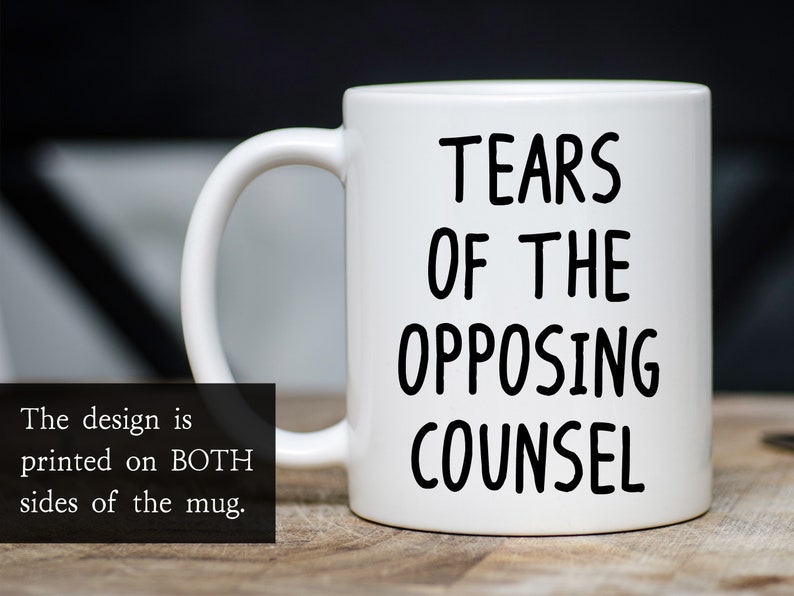 May include: White ceramic coffee mug with black text that reads "Tears of the Opposing Counsel".