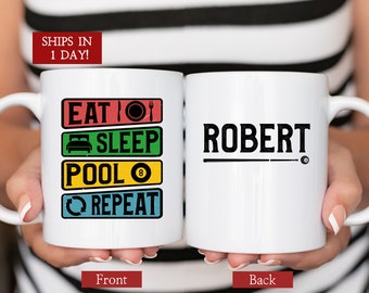 May include: White ceramic mug with a colorful graphic that reads "Eat, Sleep, Pool, Repeat" and a black 8-ball. The back of the mug has the name "Robert" in black text with a black pool cue and 8-ball.