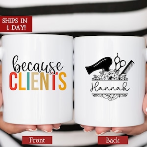May include: White ceramic mug with the text "because clients" in rainbow colors on the front and a black and white illustration of a hairdryer, scissors, and comb with the name "Hannah" on the back.