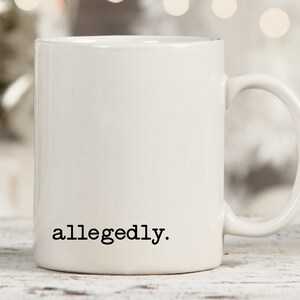 May include: White ceramic coffee mug with the text "allegedly." printed in black on the front.