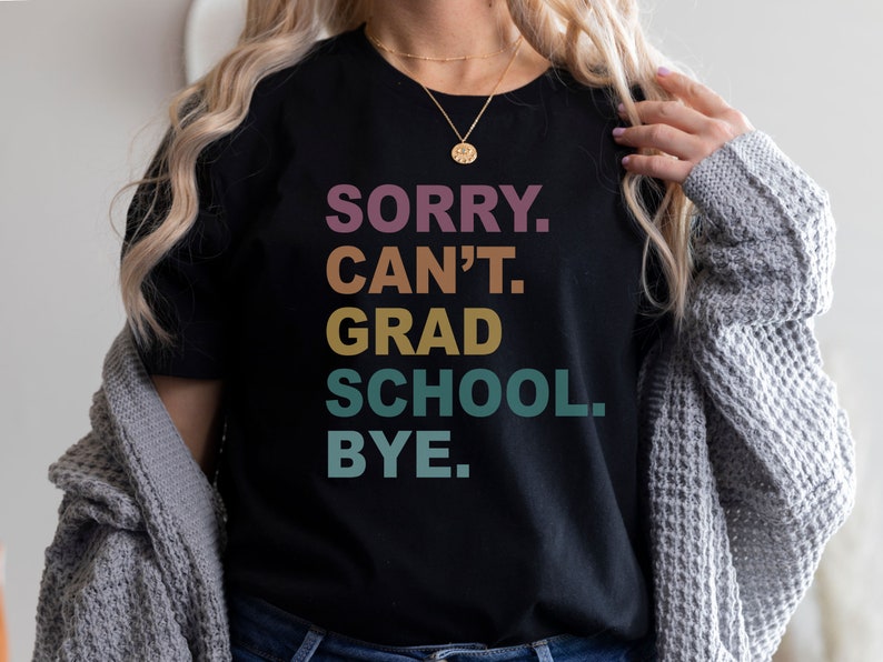 Może przedstawiać: Czarny T-shirt z napisem "SORRY. CAN'T. GRAD SCHOOL. BYE." w tęczowym gradiencie kolor&oacute;w.