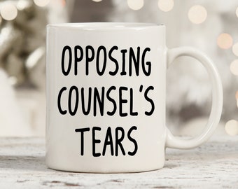 May include: White ceramic coffee mug with black text that reads "Opposing Counsel's Tears".