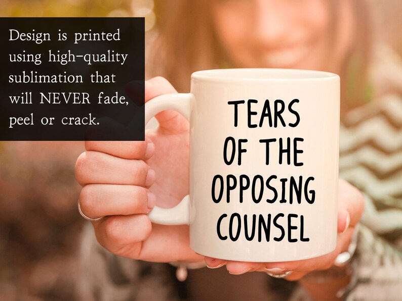 May include: White ceramic coffee mug with black text that reads "Tears of the Opposing Counsel".