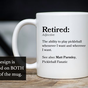 May include: White ceramic coffee mug with a black design that says "Retired: Adjective The ability to play pickleball whenever I want and wherever I want. See also: Matt Parmley, Pickleball Fanatic"