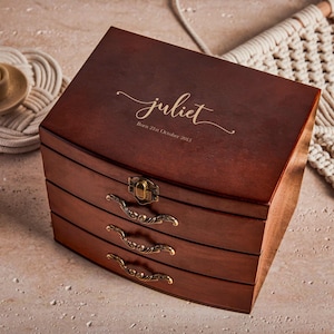 May include: A wooden jewelry box with three drawers and a curved lid. The lid is engraved with the name "juliet" and the date "Born 21st October 2013".