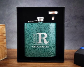 May include: A green metal flask with a silver lid and funnel. The flask is engraved with the text "Randy Groomman" and the letter "R".