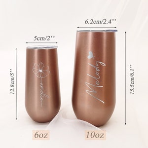 May include: Two rose gold stainless steel tumblers with personalized engravings. The smaller tumbler is 6 ounces and engraved with "amelie" and a flower. The larger tumbler is 10 ounces and engraved with "Melody" and a heart.