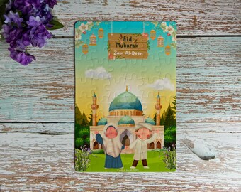 May include: A colorful jigsaw puzzle featuring a mosque with a blue dome and two children in front of it. The puzzle has the text "Eid Mubarak Zain Al-Deen" on it.