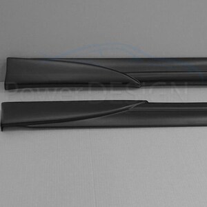 Puede incluir: Un par de faldones laterales negros para un coche. Los faldones est&aacute;n hechos de un material liso y duradero y tienen un dise&ntilde;o elegante y moderno.