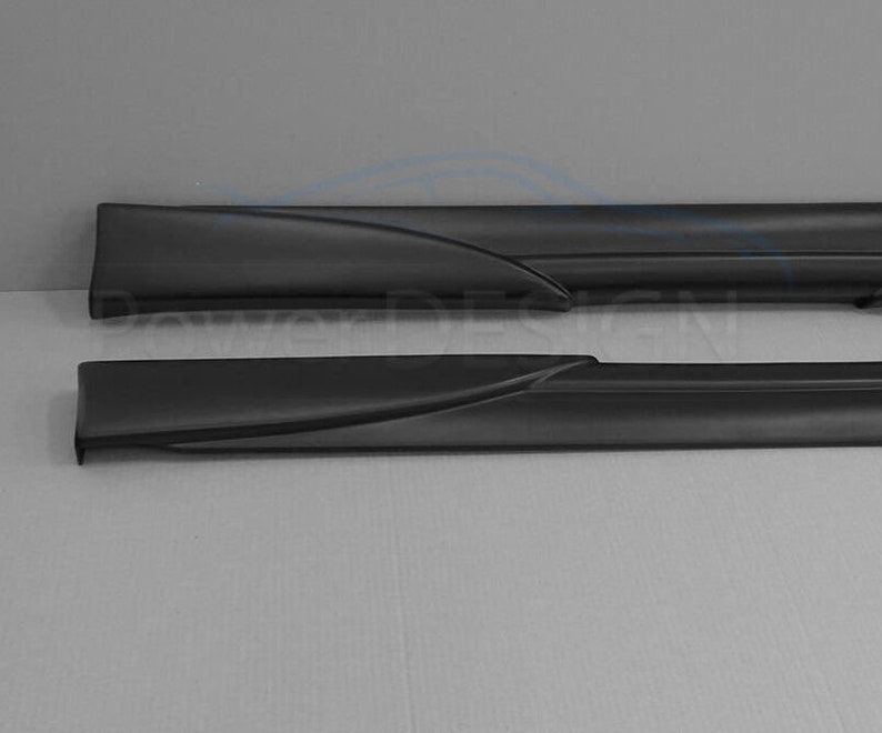 Puede incluir: Un par de faldones laterales negros para un coche. Los faldones est&aacute;n hechos de un material liso y duradero y tienen un dise&ntilde;o elegante y moderno.