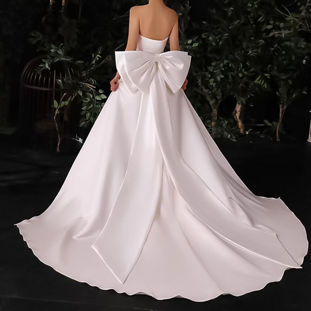 Ivory satin dress decorated with crystals and bow