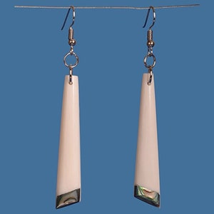 May include: A pair of long, white, dangle earrings with a silver hook and a small iridescent abalone shell accent at the bottom.