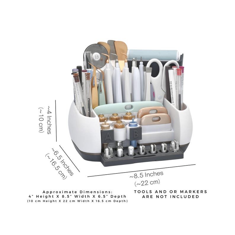 May include: White and gray craft organizer with multiple compartments for tools. It measures approximately 4 inches (10 cm) high, 8.5 inches (22 cm) wide, and 6.5 inches (16.5 cm) deep. Tools and markers are not included.
