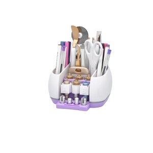 Puede incluir: Un organizador de manualidades blanco y morado lleno de varias herramientas, incluyendo bol&iacute;grafos, tijeras y una esp&aacute;tula. El organizador tiene m&uacute;ltiples compartimentos y una base con componentes etiquetados. Las herramientas est&aacute;n dispuestas para un f&aacute;cil acceso.