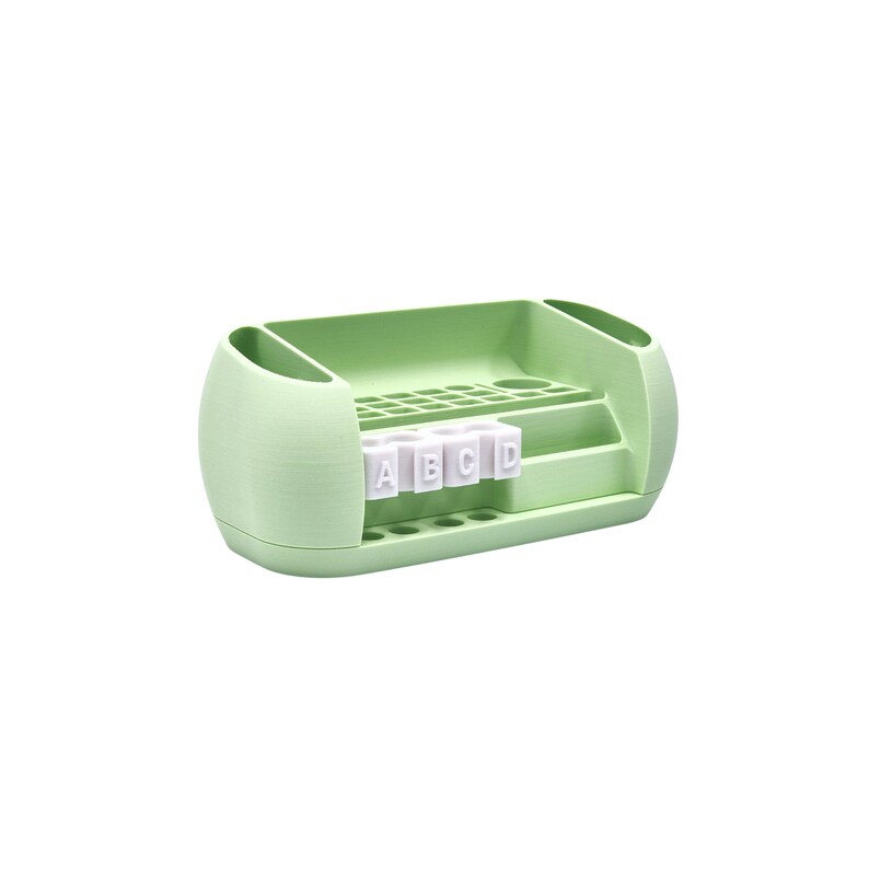 Puede incluir: Un organizador de escritorio verde claro con m&uacute;ltiples compartimentos y una superficie texturizada. Cuenta con ranuras para bol&iacute;grafos, l&aacute;pices y otros suministros, as&iacute; como una secci&oacute;n con las letras A, B, C y D. Dise&ntilde;ado para mantener un escritorio ordenado.