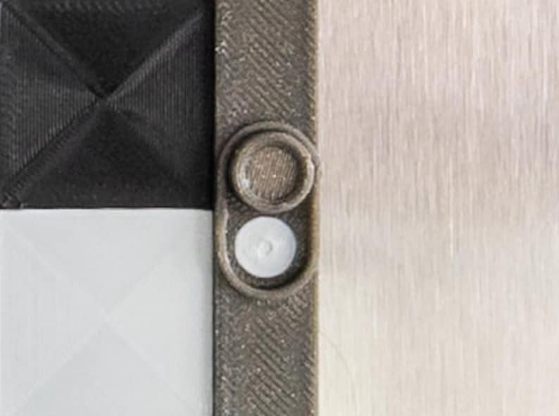 May include: Close-up of a gray and black chessboard with a white and gray plastic piece on the side.