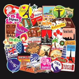 Könnte beinhalten: Eine Sammlung bunter Reisesticker mit Sehenswürdigkeiten, Flaggen und Texten aus aller Welt, darunter Japan, Paris, London, Australien und mehr.