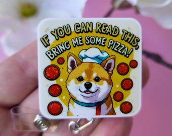 Puede incluir: Una insignia cuadrada con un Shiba Inu de dibujos animados que lleva un gorro de chef y un cuello azul. La insignia tiene el texto "IF YOU CAN READ THIS, BRING ME SOME PIZZA!" y está decorada con rodajas de pizza de pepperoni.