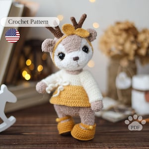 Modello all'uncinetto per cervi. Cervo di peluche amigurumi in un vestito. Cerbiatto della foresta all'uncinetto